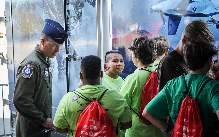 Col. Douglas Gosney, 14th Flying Training Wing Commander, talks to students as they wait in line for the Rapid Strike simulator Oct. 3, 2017, during the Imagine the Possibilities Career Expo at the BancorpSouth Arena in Tupelo, Mississippi. Airmen from Columbus AFB represented seven pathways at the expo, including aerospace, communications, engineering, government and public administration, health sciences, logistics and law and public safety. (U.S. Air Force photo by Staff Sgt. Christopher Gross)