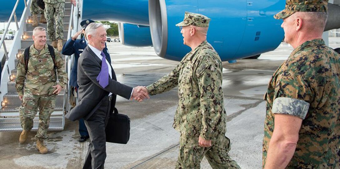 Defense Secretary Jim Mattis shakes hands with a service member on a flightline.