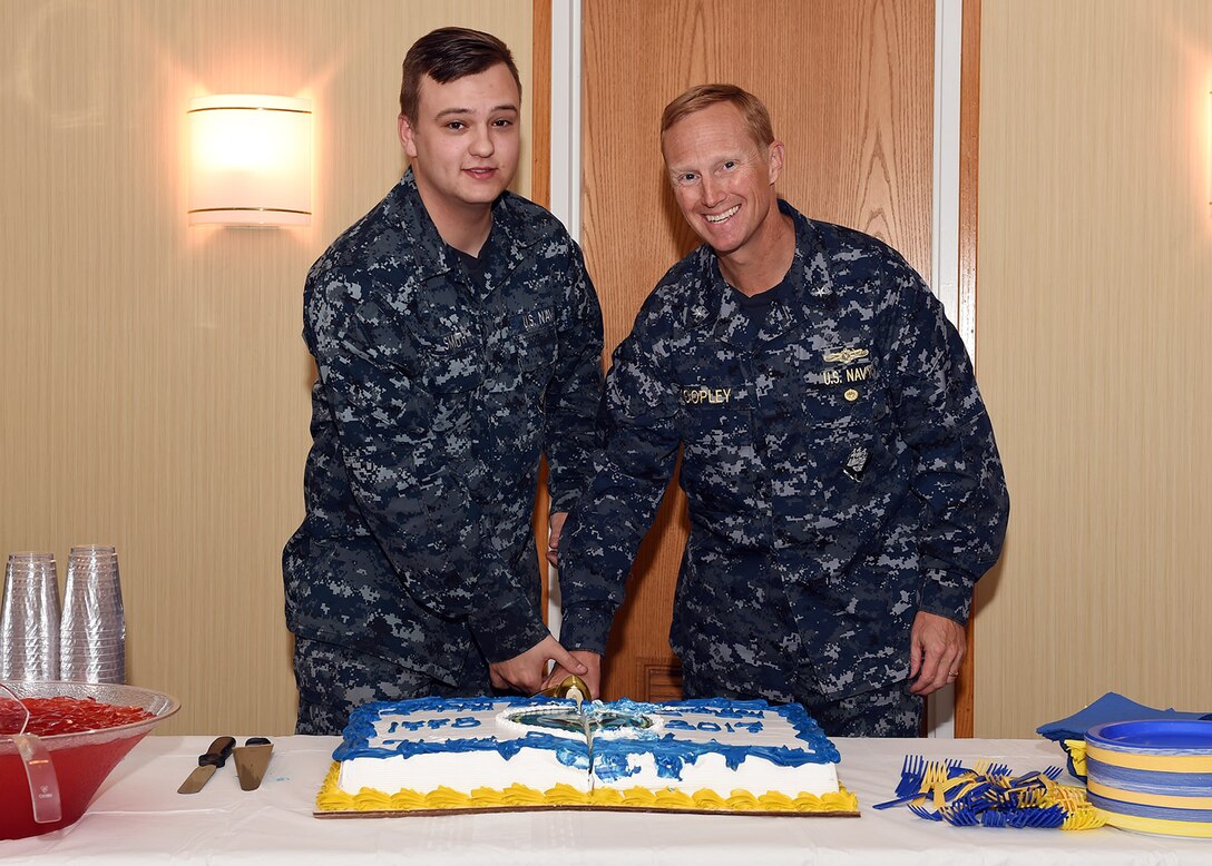 Information System Technician Seaman Daniel Smith and Rear Adm. Curt Copley, U.S. Strategic Command (USSTRATCOM) Navy Element Commander and Director of Intelligence, cut a cake during the Navy’s 242nd birthday ceremony at USSTRATCOM on Offutt Air Force Base, Neb., Oct. 13, 2017.