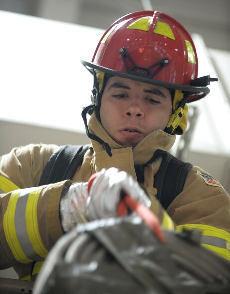 Airman Jefre Turcios-Rivera, a heating ventilation air conditioning and refrigeration technician assigned to the 28th Civil Engineer Squadron, pulls a hose over a railing during the annual Firefighter Challenge at Ellsworth Air Force Base, S.D., Oct. 6, 2017. The Firefighter Challenge included five obstacles where teams of four tried to complete the course with the fastest time possible. (U.S. Air Force photo by Airman 1st Class Thomas Karol)