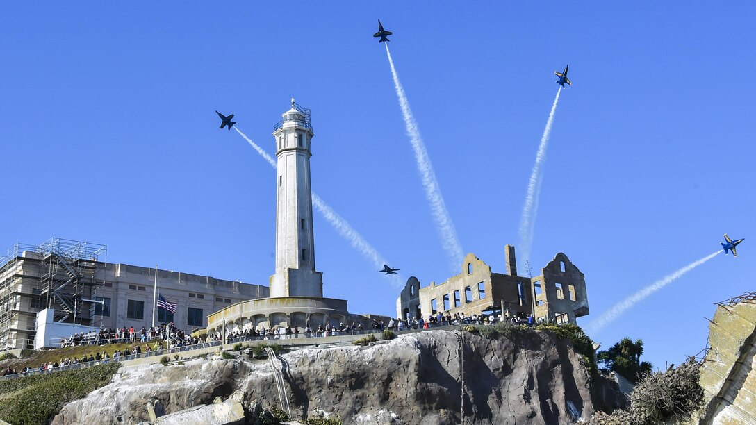 Four aircraft perform a maneuver over Alcatraz Island.