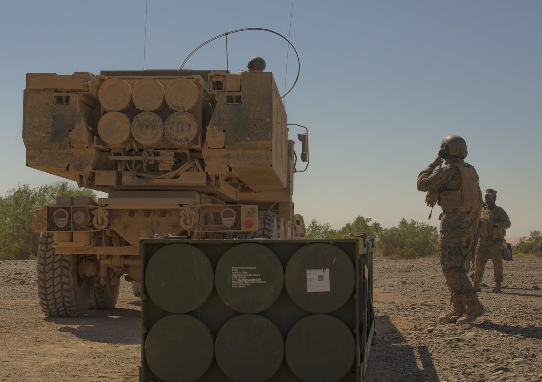 Sgt. Jansen Davis (front right), a section chief with 3rd Platoon, Rocket Battery F, 2nd Battalion, 14th Marine Regiment, 4th Marine Division, Marine Forces Reserve, gives instruction to Lance Cpl. Justin Minor (left), a gunner with 2/14, as he guides the unloading and loading of an M142 High Mobility Artillery Rocket System during Weapons and Tactics Instructor course 1-18 at Landing Zone Bull Attack, near the Chocolate Mountain Aerial Gunnery Range, California, Oct. 11, 2017.
