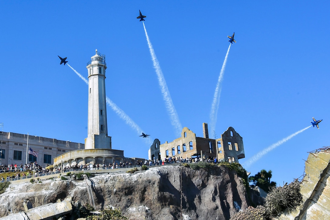 Four aircraft perform a maneuver over Alcatraz Island.