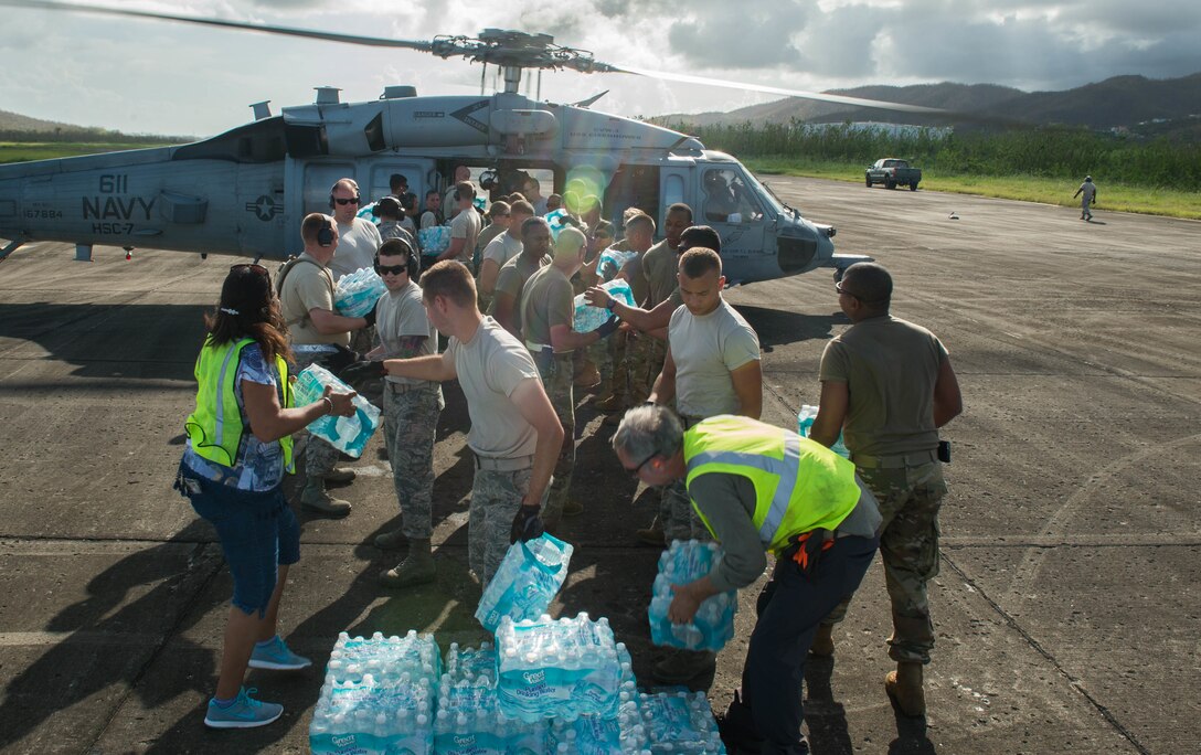 Airmen, soldiers and Federal Emergency Management Agency personnel load food and water onto a helicopter at Roosevelt Roads, Puerto Rico.