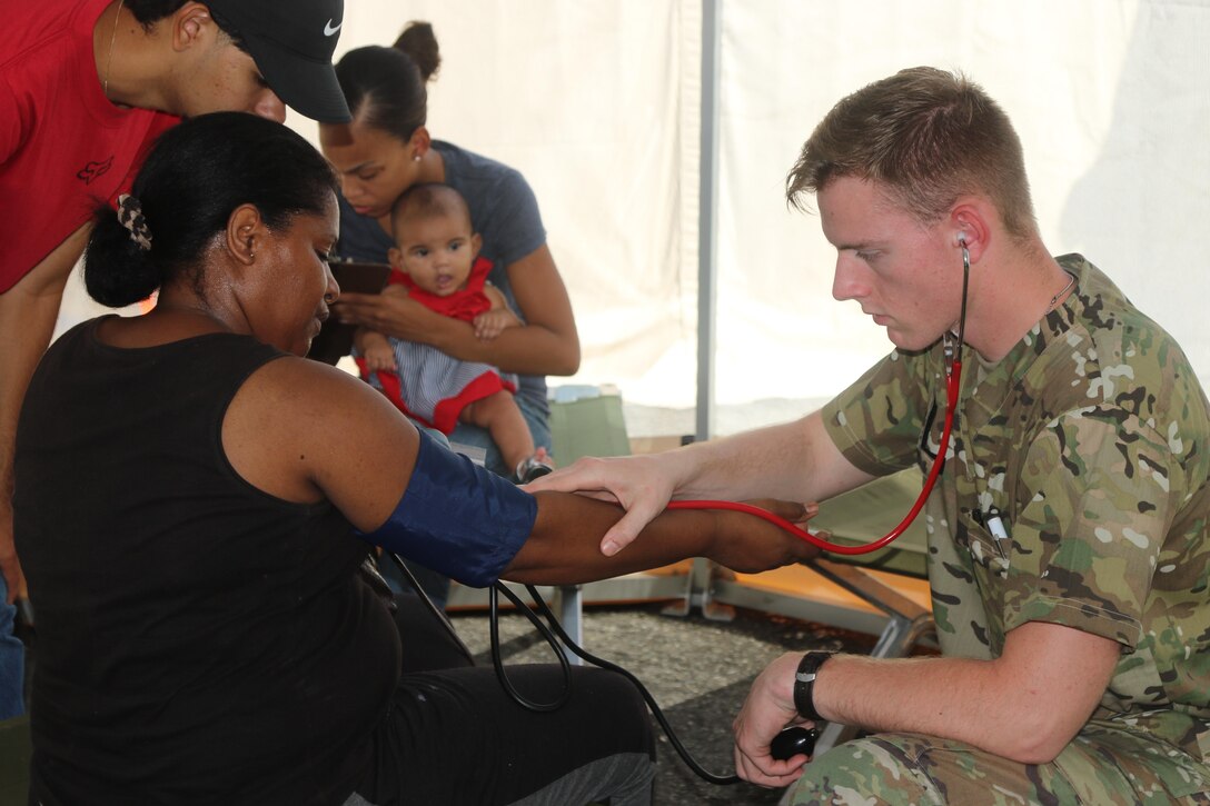 A medic with the 1st Armored Division, tends to patients near Fajardo, Puerto Rico.