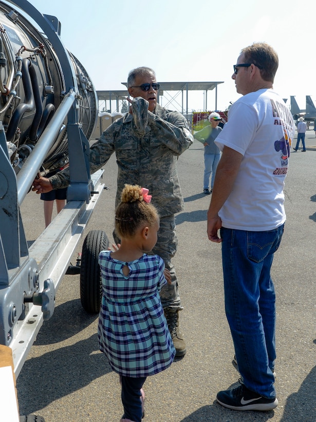 U.S. Air Force Tech. Sgt. John Valles, 144th Aircraft Maintenance Group engine shop, explains how a jet engine operates to a crowd of attendees.