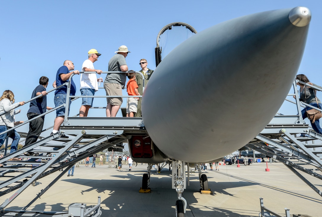 Crowds gather around a static display of an F-15C fighter jet Eagle.