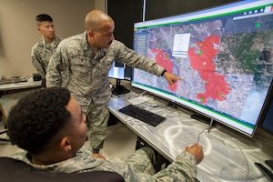Staff Sgt. Richard Glover, 163d Attack Wing IT Specialist, shows burn areas to Staff Sgt. Jamel Seales (sitting) and Staff Sgt. Shawn Blue (background) on Saturday, Oct. 14, 2017, at the wing's Hap Arnold Center at March Air Reserve Base, California.