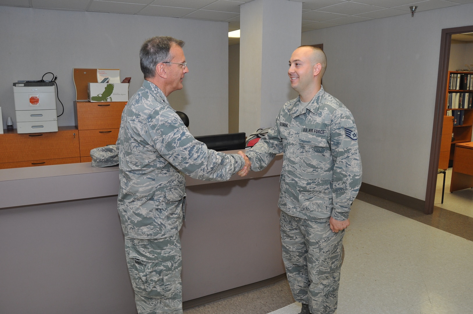 Maj. Gen. Randall Ogden, 4th Air Force commander, presents a commander's coin to Staff Sgt. Isaiah Estrada, 433rd Civil Engineer Squadron contractor, Oct. 15, 2017 for his accomplishments and achievements within the squadron. Both Gen. Ogden and Chief Master Sgt. Timothy White, Jr., 4th AF command chief, presented approximately 14 commanders coins to outstanding Reserve Citizen Airmen during their four-day visit to the 433rd Airlift Wing. (U.S. Air Force photo/Senior Airman Bryan Swink)