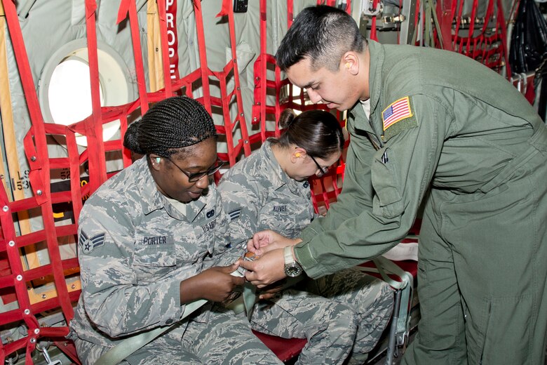 U.S. Air Force Reserve Tech Sgt. Matthew Masterson, a loadmaster assigned to the 327th Airlift Squadron, assists passengers with their seatbelts before take-off on an incentive flight Oct. 14, 2017, at Little Rock Air Force Base, Ark.