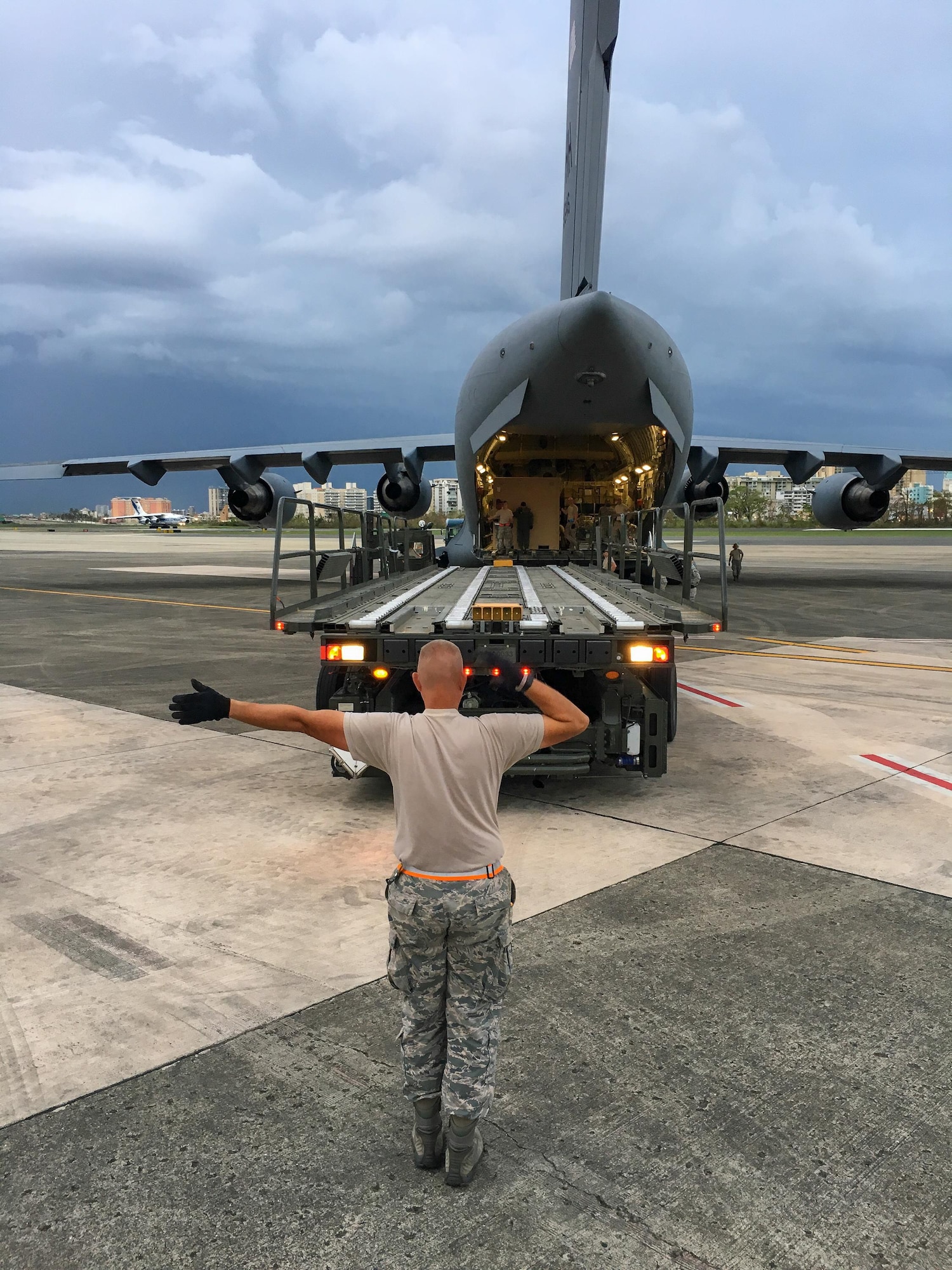 An Airman from the Kentucky Air National Guard’s 123rd Contingency Response Group directs the dowload of relief supplies from a U.S. Air Force C-17 aircraft at Luis Muñoz Marín International Airport in San Juan, Puerto Rico, in the wake of Hurricane Maria Oct. 5, 2017. The unit’s Airmen established an aerial port of debarkation upon arrival here Sept. 23, and have processed more than 7.2 million pounds of cargo and humanitarian aid for distribution in the first three weeks of the operation. (U.S. Air National Guard photo by Lt. Col. Dale Greer)