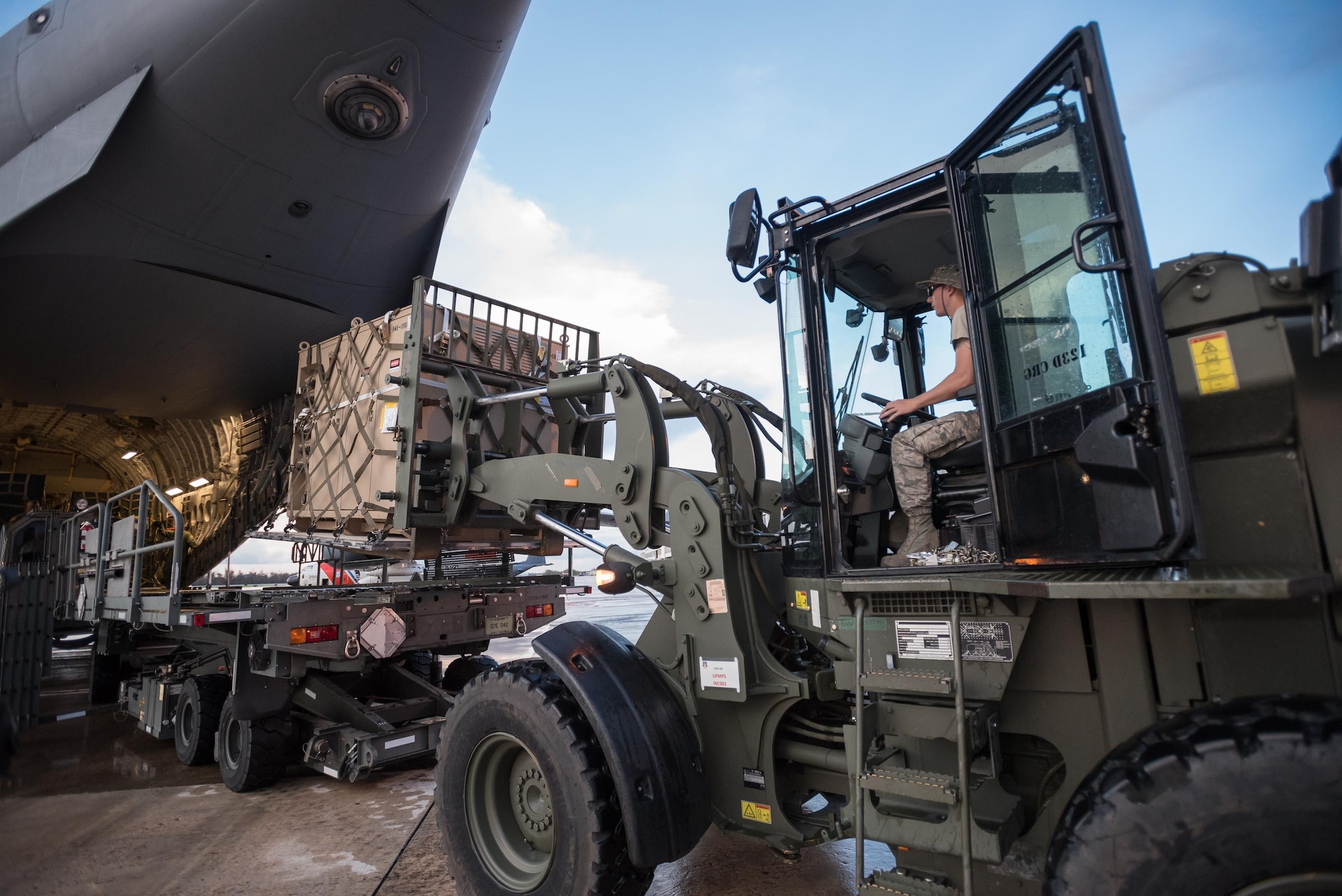 Airmen from the Kentucky Air National Guard’s 123rd Contingency Response Group, augmented by troops from the active-duty Air Force and Air National Guard units in multiple states, dowload relief supplies from aircraft around the clock at Luis Muñoz Marín International Airport in San Juan, Puerto Rico, in the wake of Hurricane Maria Oct. 6, 2017. The unit’s Airmen established an aerial port of debarkation upon arrival here Sept. 23, and have processed more than 7.2 million pounds of cargo and humanitarian aid for distribution in the first three weeks of the operation. (U.S. Air National Guard photo by Lt. Col. Dale Greer)