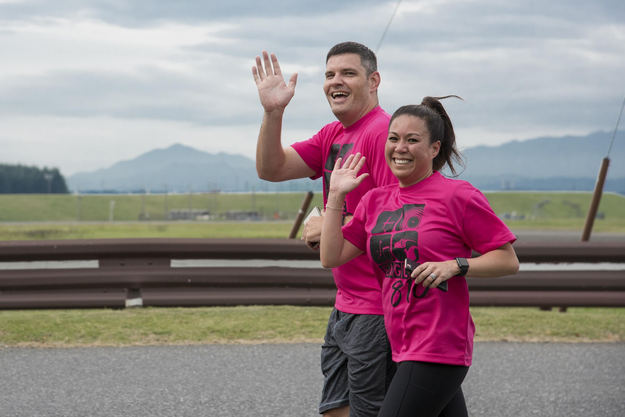 Participants wave their hands while running during the Breast Cancer Awareness Month 5K run at Yokota Air Base, Japan, Oct. 06, 2017.