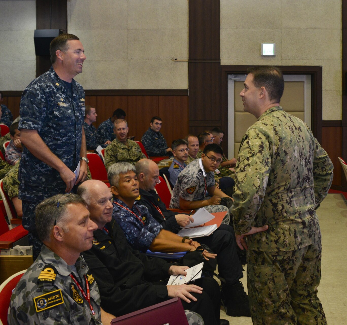 BUSAN, Republic of Korea (Oct. 12, 2017) Rear Adm. Brad Cooper, commander, U.S. Naval Forces Korea (CNFK), speaks with LCDR William A. Russell, commanding officer aboard the Avenger-class mine countermeasures ship USS Chief (MCM 14), at the fourth annual Mine Countermeasures (MCM) Symposium. The symposium's purpose is to enhance interoperability, coordination and training in mine countermeasures capabilities between U.S., ROK, and UNC SS forces.