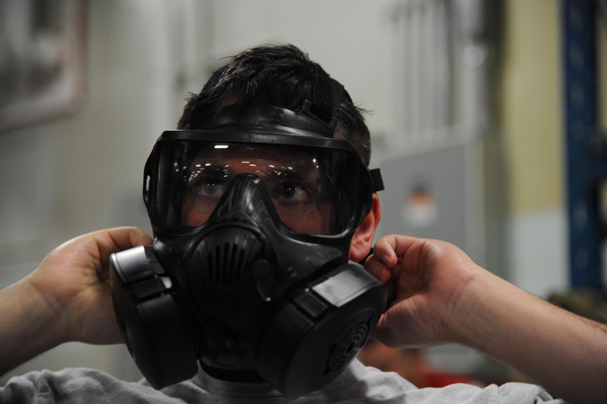 An Airman assigned to the 927th Air Refueling Wing places on his gas mask during an Ability to Survive and Operate exercise on Oct. 15, 2017 at MacDill Air Force Base, FL. The ATSO exercise was designed to sharpen Airmen's skills and their ability to operate while in a chemical warfare environment. (U.S. Air Force photo by Staff Sgt. Xavier Lockley)