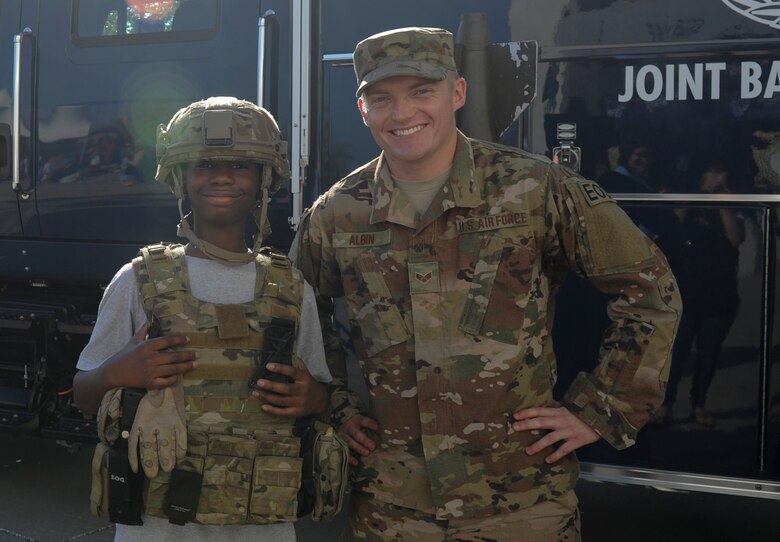 Senior Airman Jonathan Albin, 628th Civil Engineer Squadron Explosive Ordnance Disposal Flight explosive ordnance disposal journeyman, poses for a photo with a member of the Charleston community wearing a helmet and plate carrier vest at the Johnson Hagood Memorial Stadium for the Citadel’s Military Appreciation Night, Oct. 14, 2017. Members of the 628th Security Forces Squadron and 437th Airlift Wing represented Joint Base Charleston at the football game. Additionally, the Citadel hosted women’s soccer and volleyball games in support of Military Appreciation Week. The Citadel Bulldog’s football game against the Wofford Terriers was the capstone event, with Woffard winning 20-16.