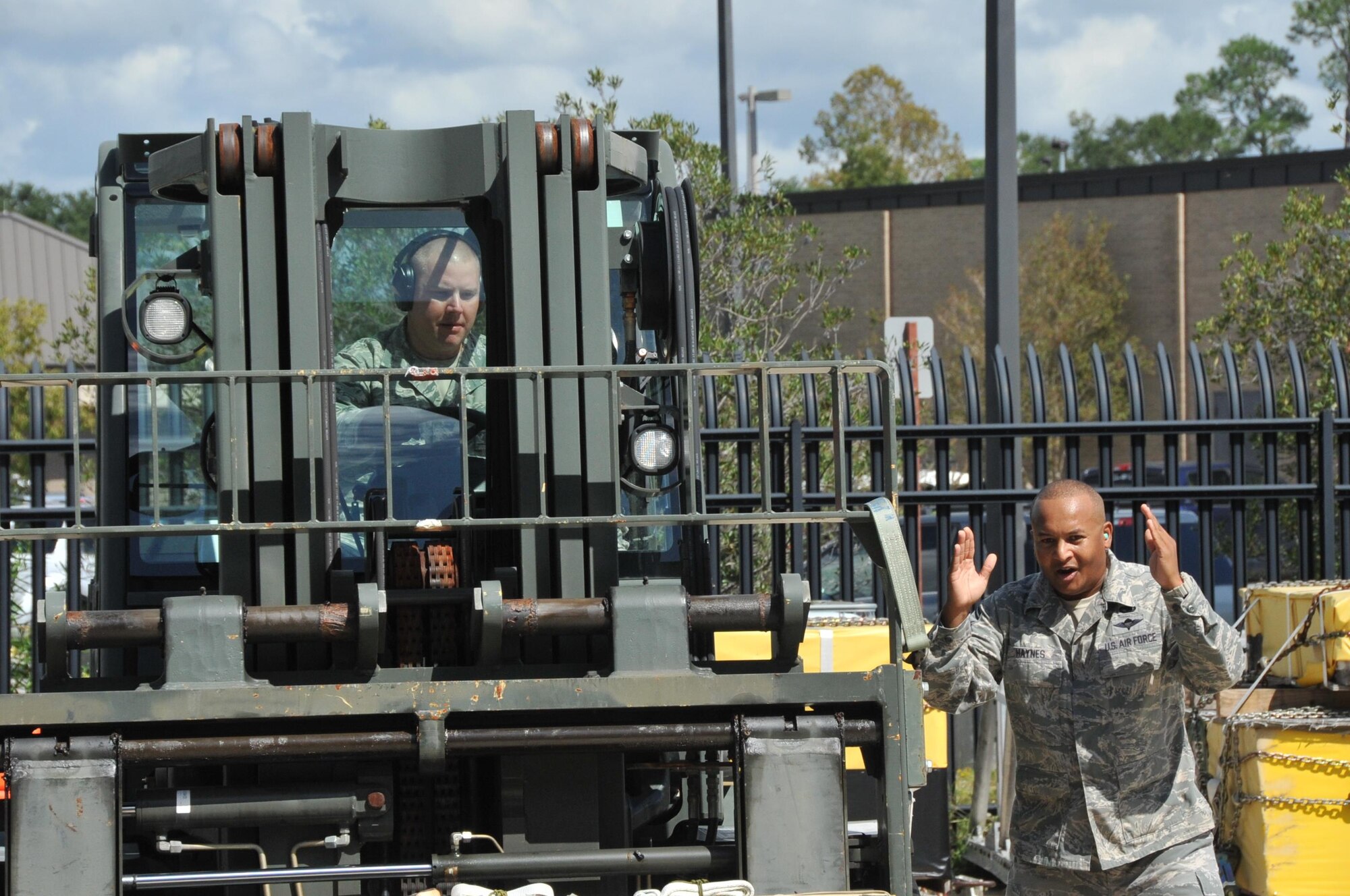Members of Team Gaston, 41st Aerial Port Squadron air transportation craftsmen Senior Master Edrick Haynes, spotter, and Tech. Sgt. Major Sims, driver, work together during the forklift obstacle course event of the annual Port Dawg Challenge here Oct. 14, 2017.  Members of the 41st Aerial Port Squadron competed in teams during the annual Port Dawg Challenge, which consisted of five events: cargo pallet build-up, chains and devices, forklift obstacle course, Jeopardy, and a Fit-to-Fight relay.  (U.S. Air Force Photo/ Master Sgt. Jessica Kendziorek)