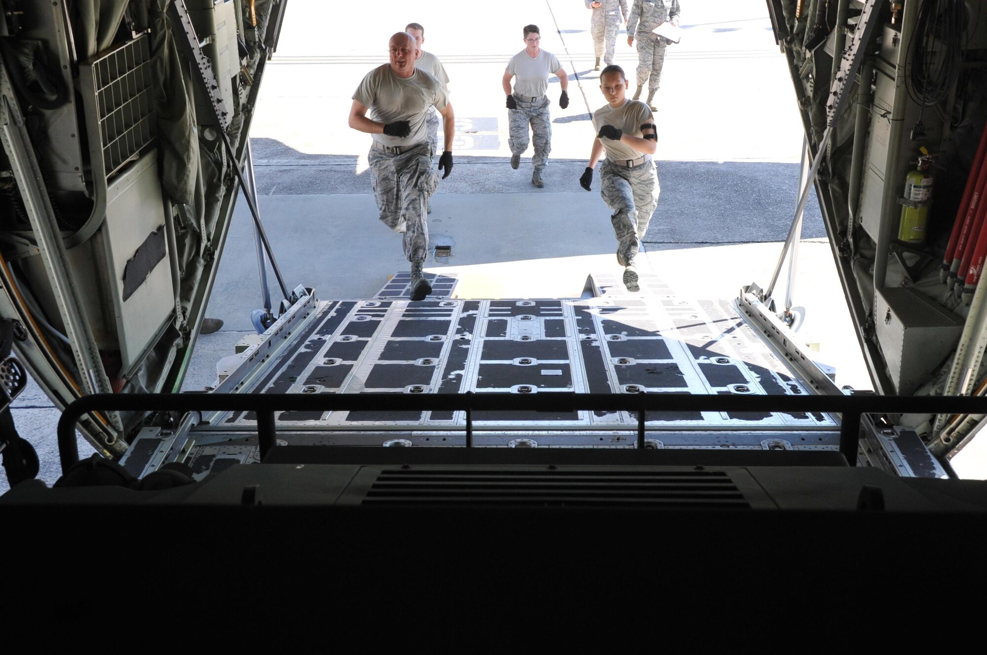 Members of Team Christofferson, 41st Aerial Port Squadron air transportation specialists race to the C-130J aircraft during the chains and devices event portion of the annual Port Dawg Challenge here Oct. 14, 2017.  Members of the 41st Aerial Port Squadron competed in teams during the annual Port Dawg Challenge, which consisted of five events: cargo pallet build-up, chains and devices, forklift obstacle course, Jeopardy, and a Fit-to-Fight relay.  (U.S. Air Force Photo/ Master Sgt. Jessica Kendziorek)