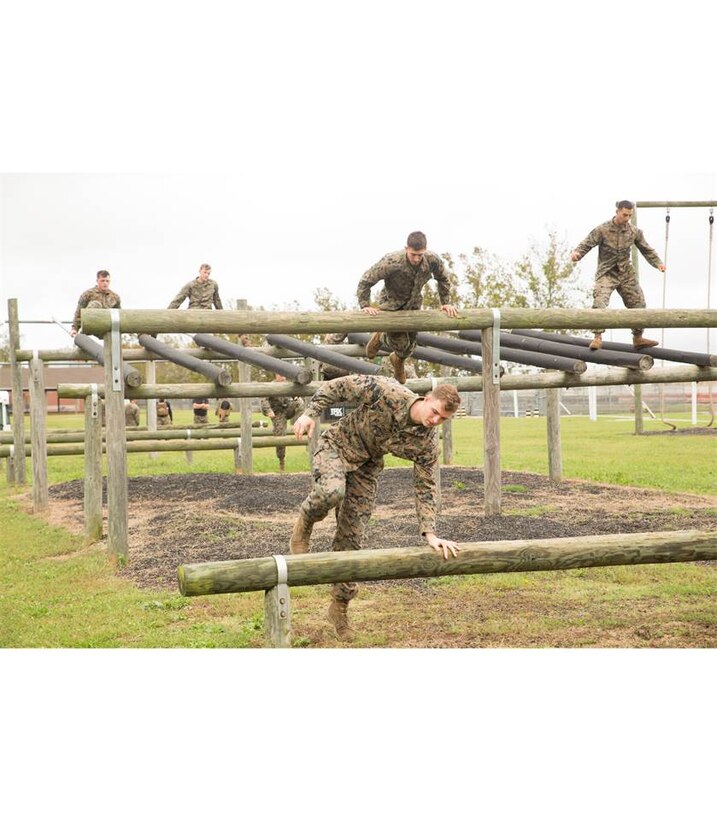Marines from various units throughout the Hampton Roads area negotiate the obstacle course during their physical conditioning session aboard Camp Allen, in Norfolk, Va., Oct. 13,  during a Marine Corps Martial Arts Instructor Course class. Along with the obstacle course, Marines participated in other exercises  such as squad push-ups and crunches. (Official Marine Corps photo by Chris Jones/Released)