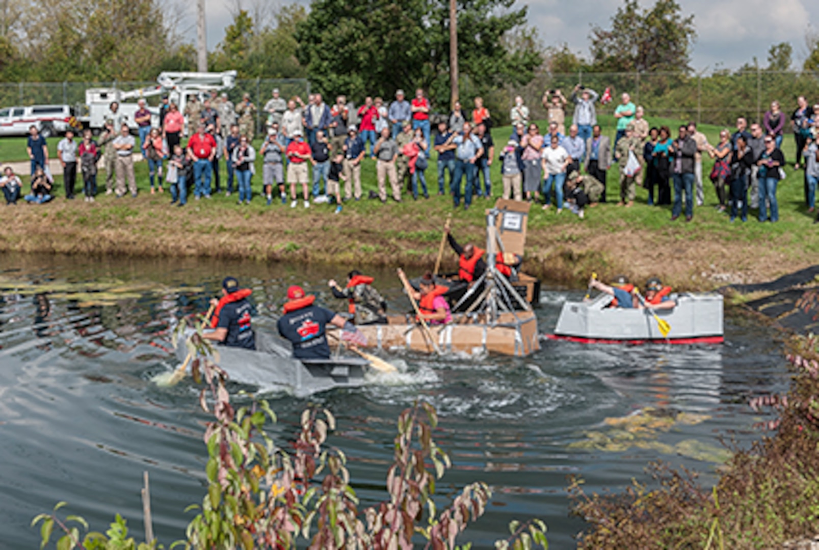 Associates surrounded the Eagle Eye Golf Course pond to watch teams compete in the 3rd Annual Cardboard Regatta