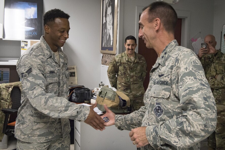 U.S. Air Force Maj. Gen. Scott J. Zobrist, 9th Air Force commander, coins Senior Airman Dicarlo Howard, 20th Air Support Operations Squadron (20th ASOS) tactical air control party, Oct. 10, 2017, at Fort Drum, N.Y. During Zobrist’s visit, in addition to learning about the 20th ASOS mission, he thanked Airmen for their service and dedication to the mission. (U.S. Air Force photo by Senior Airman Janiqua P. Robinson)