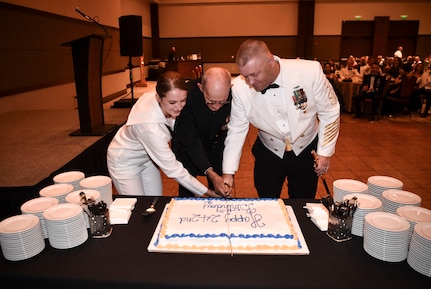 The youngest and oldest Sailor at the Navy’s 242nd birthday ball cut the cake with Naval Support Activity Command Master Chief Asa Worcester, Oct. 14, 2017.