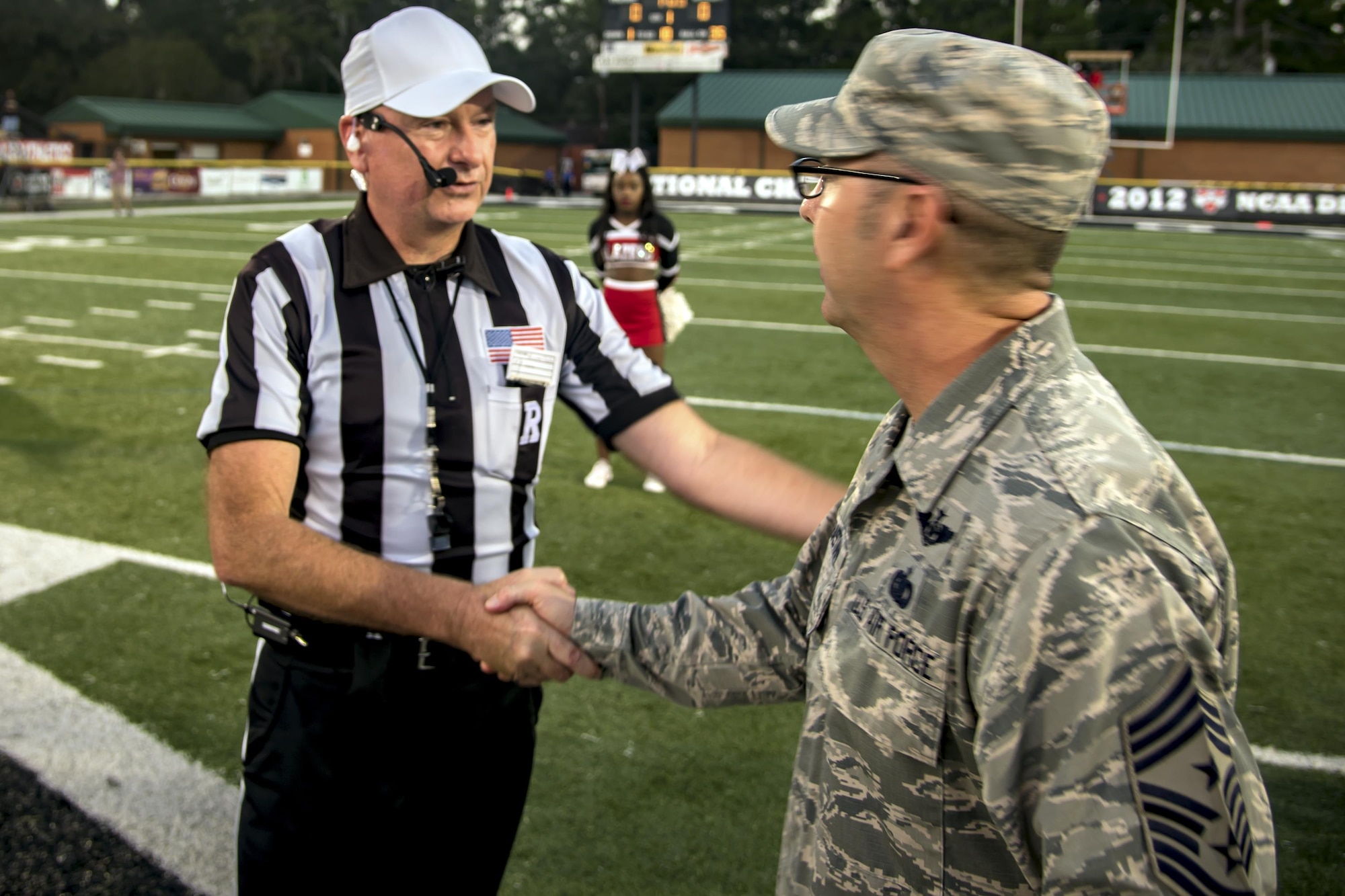 Chief Master Sgt. Jarrod Sebastian, 23d Wing command chief, receives a coin from Michael Lester, college football referee, prior to a military appreciation day game, Oct. 15, 2017, in Valdosta, Ga. Active-duty and retired military members received free admission into the game as appreciation for their service. (U.S. Air Force photo by Airman Eugene Oliver)