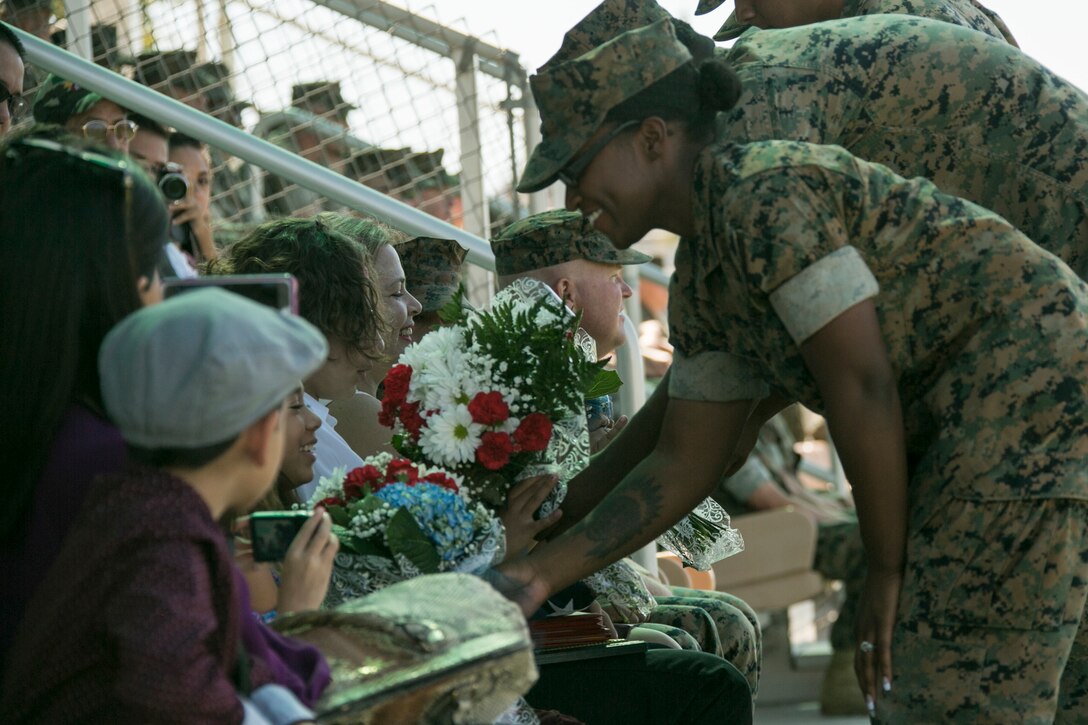 Marines present flowers to the family of  Sgt. Maj. Avery Crespin, former Headquarters Battalion sergeant major, during his retirement ceremony at Lance Cpl. Torrey L. Gray field aboard the Combat Center, September 29, 2017. Crespin served in more than five units and Military Occupational Specialties in his 22 years of active duty service. (U.S. Marine Corps photo by Lance Cpl. Isaac Cantrell)