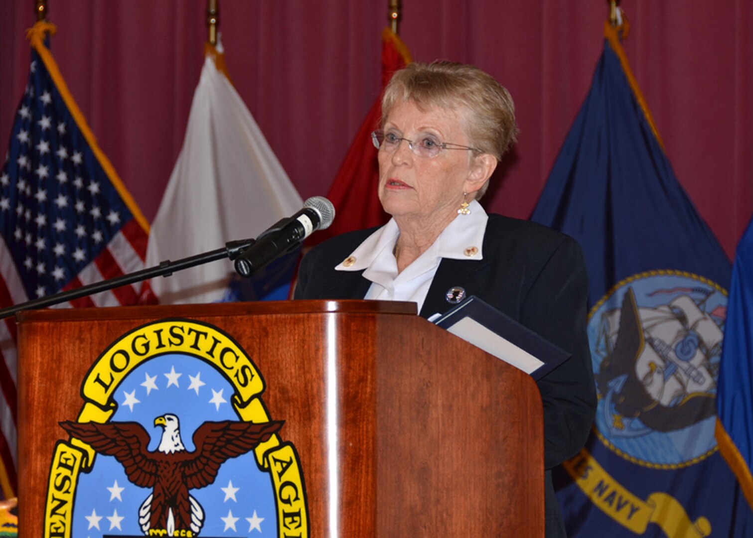 Dassa Carvey speaks at a podium.