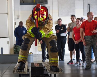 A U.S. Air Force Airman moves a weight with a sledgehammer during the Fire Prevention Week Firefighter’s Combat Challenge at Joint Base Langley-Eustis, Va., Oct. 13, 2017.