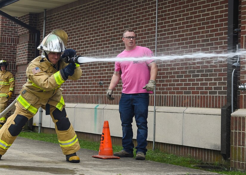 A U.S. Air Force Airman sprays water during the Fire Prevention Week Firefighter’s Combat Challenge at Joint Base Langley-Eustis, Va., Oct. 13, 2017.