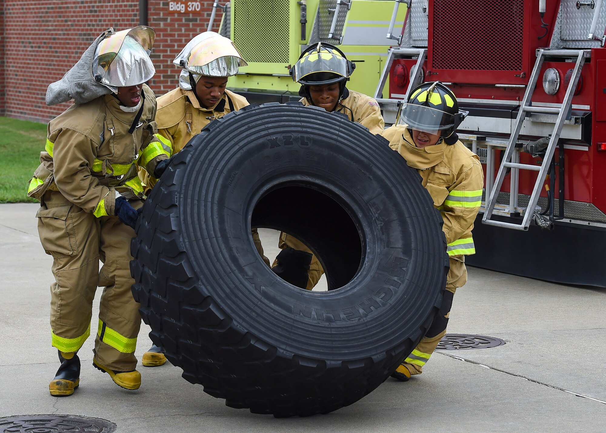 U.S. Air Force Airmen flip a tire during the Fire Prevention Week Firefighter’s Combat Challenge at Joint Base Langley-Eustis, Va., Oct. 13, 2017.