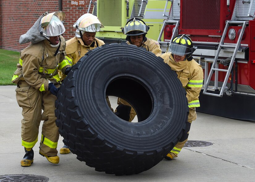 U.S. Air Force Airmen flip a tire during the Fire Prevention Week Firefighter’s Combat Challenge at Joint Base Langley-Eustis, Va., Oct. 13, 2017.