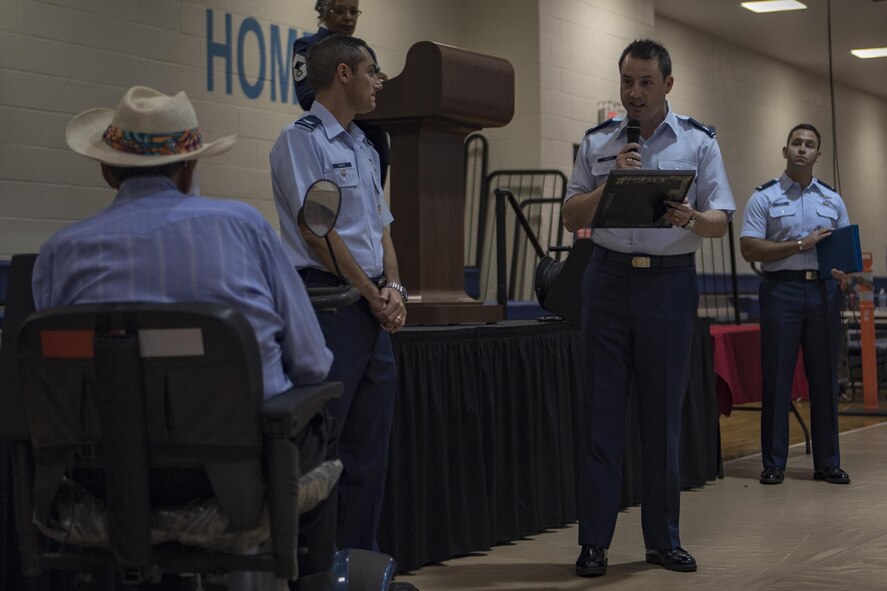 Col. Justin DeMarco, 23d Wing vice commander, left, and Lt. Col. Mack Coker, 23d Mission Support Group deputy commander, present the oldest retiree in attendance, who was 97 years old, a plaque, during a Retiree Appreciation Week event, at the Freedom 1 Fitness Center on Moody Air Force Base, Ga. Retired Chief Master Sgt. James Ingram, director of the Retiree Affairs Office, created the annual event in the 1990’s to bring retirees together and make them feel welcomed in the base community. (U.S. Air Force photo by Senior Airman Daniel Snider)