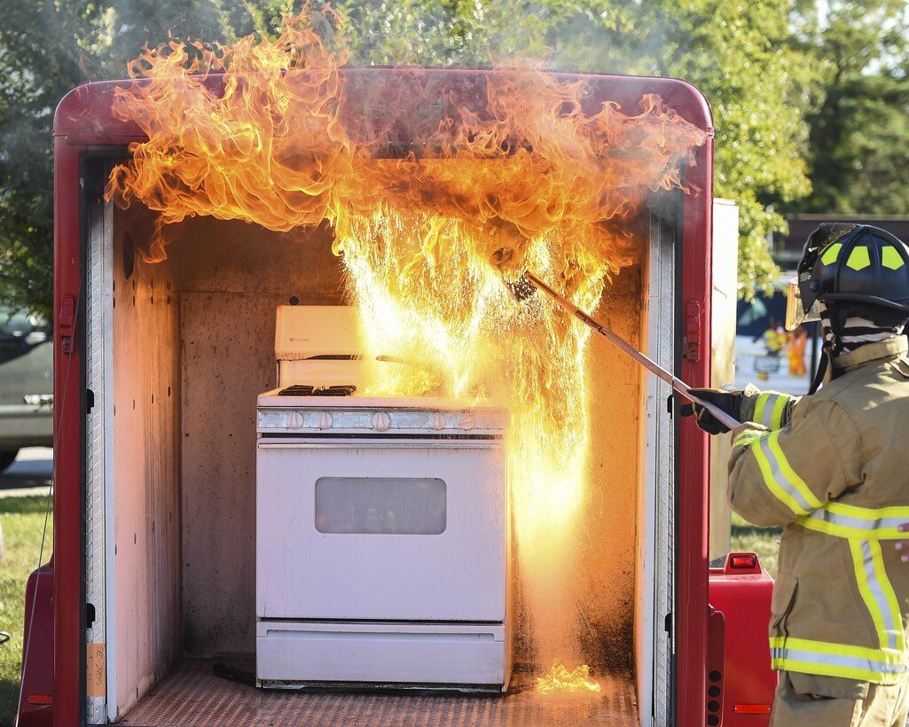 U.S. Air Force Airman 1st Class Micah Butler, 633rd Civil Engineer Squadron firefighter, pours water over a pot with hot grease during a kitchen fire demonstration at Bethel Manor Housing, Yorktown, Va., Oct. 6, 2017.