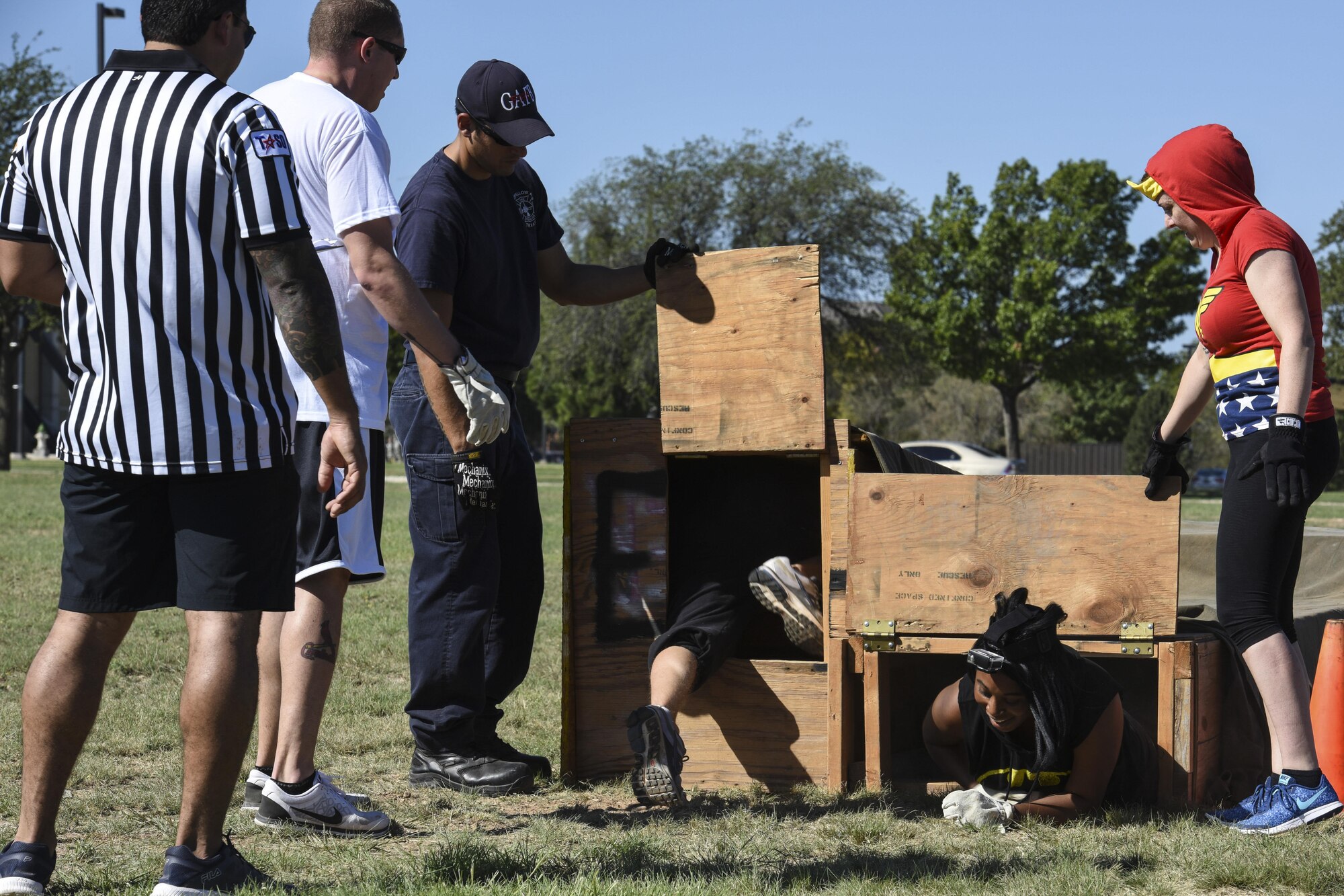 The 17th Training Wing Public Affairs team cheer each other on while completing an obstacle course during the Fire Muster Challenge beside the Fire Department on Goodfellow Air Force Base, Texas Oct. 13, 2017. The course was set up to simulate maneuvering though dark and confined areas. (U.S. Air Force photo by Airman 1st Class Zachary Chapman/Released)