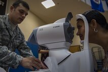 Staff Sgt. Neal Brooks, 23d Aerospace Medicine Squadron optometry technician, conducts a glaucoma screening on Debbie Benavides during a Retiree Appreciation Week event, at the Freedom 1 Fitness Center on Moody Air Force Base, Ga. Retired Chief Master Sgt. James Ingram, director of the Retiree Affairs Office, created the annual event in the 1990’s to bring retirees together and make them feel welcomed in the base community. (U.S. Air Force photo by Senior Airman Daniel Snider)