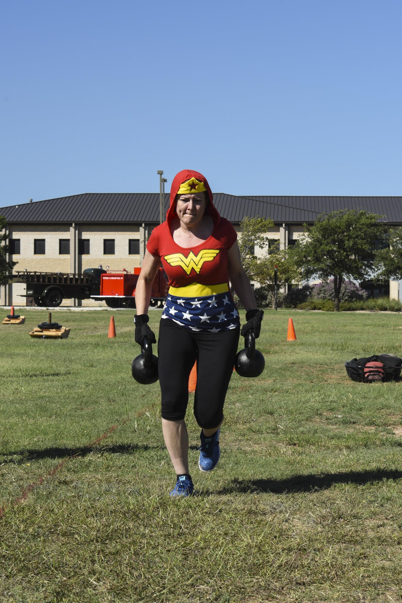 Master Sgt. Joy Meek, 17th Training Wing Public Affairs superintendent, races to the finish of the kettle bell segment of the Fire Muster Challenge beside the Fire Department on Goodfellow Air Force Base, Texas Oct. 13, 2017. Each member of the teams had to carry the kettle bells back and forth within the designated area. (U.S. Air Force photo by Airman 1st Class Zachary Chapman/Released)