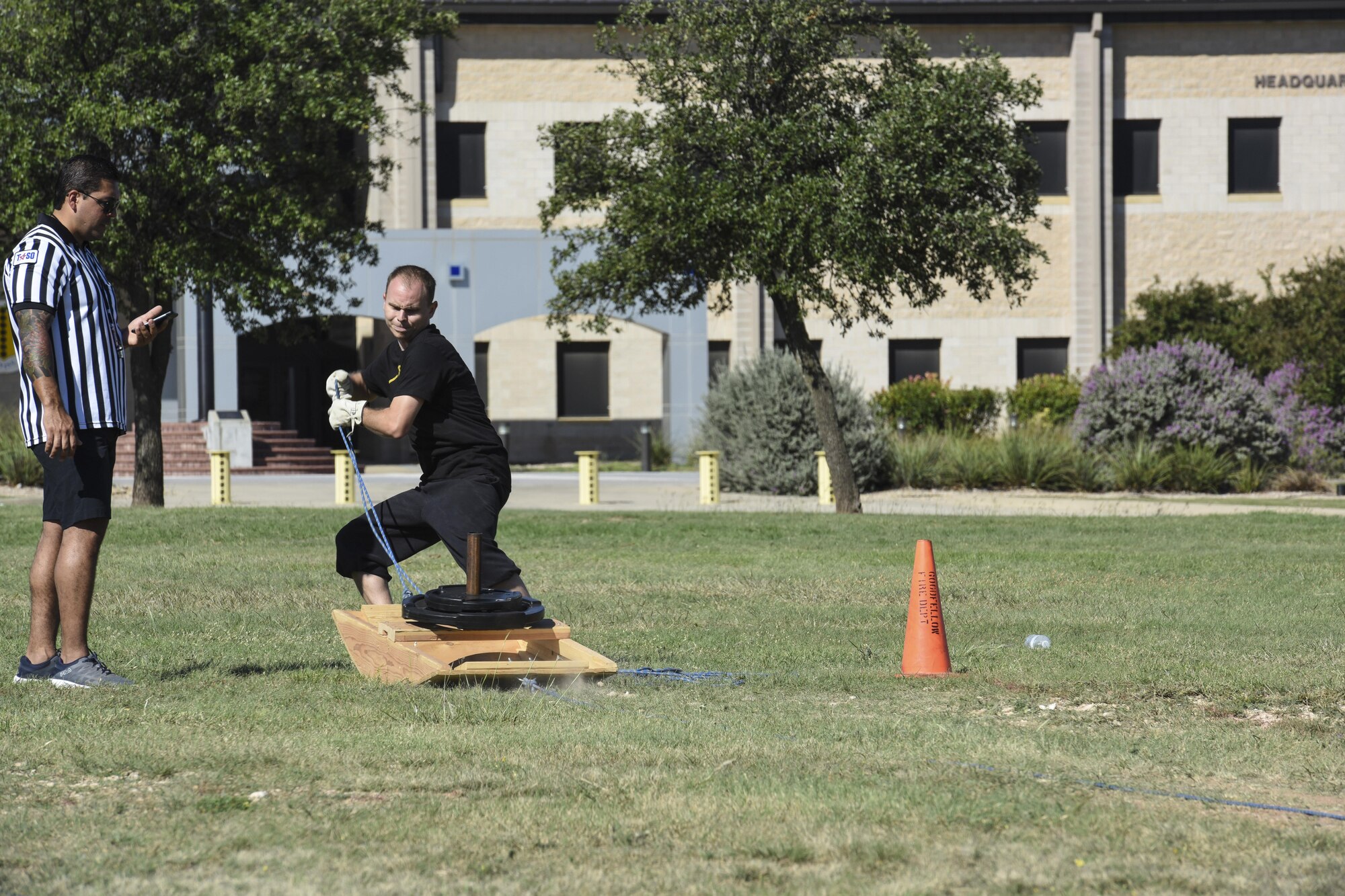 James Orlando, 17th Training Wing Public Affairs visual information specialist, pulls a sled of weights during the Fire Muster Challenge beside the Fire Department on Goodfellow Air Force Base, Texas Oct. 13, 2017. The Fire Muster Challenge tested a team’s strength and ability to work together. (U.S. Air Force photo by Airman 1st Class Zachary Chapman/Released)