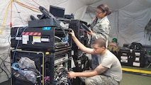 Tech. Sgt. Monica Jones, a cyber transport systems craftsman, and Senior Airman Phillip Abraham, a cyber transport systems journeyman, test a deployable Voice over Internet Protocol (VoIP) phone switch at Homestead ARB, Florida, in June.