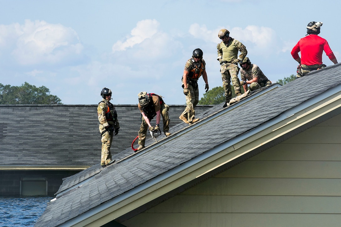 Six airmen work on a roof.