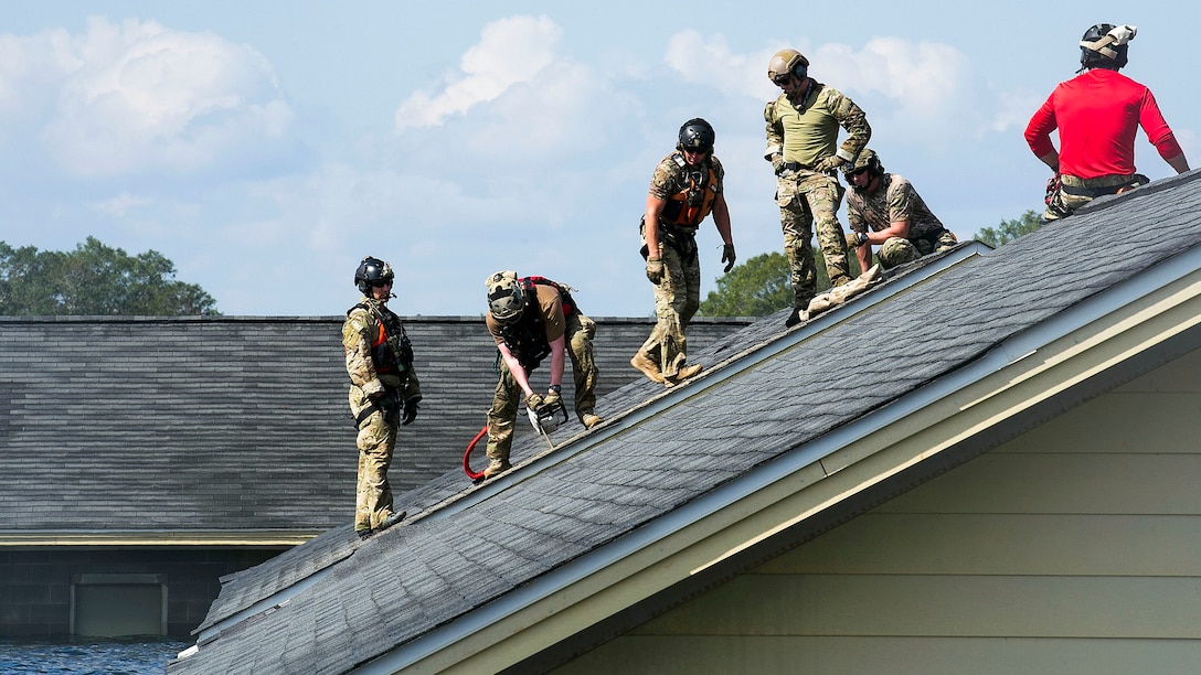 Six airmen work on a roof.