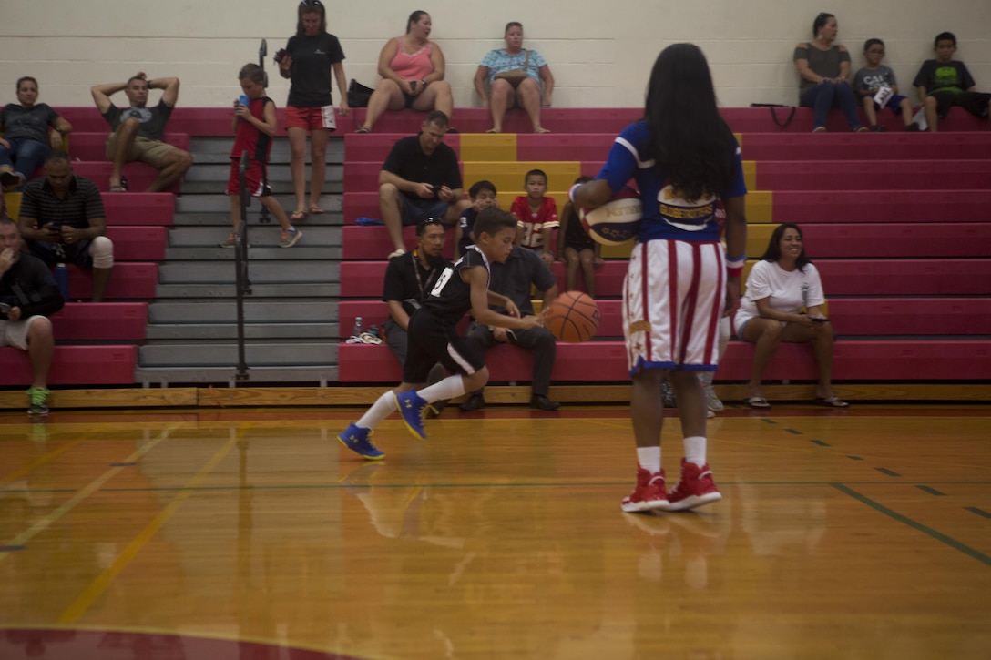 Harlem Globetrotter Fatima “TNT” Lister watches as a child completes speed drills at the Semper Fit Gym during a youth basketball clinic on Marine Corps Base Hawaii, Oct. 10, 2017. Marine Corps Community Services invited the Globetrotters to showcase their skills and put on a basketball clinic for military children on base to include shooting, dribbling and speed drills. (U.S. Marine Corps photo by Sgt. Zachary Orr)