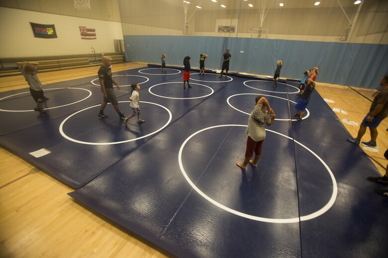 Members of Marine Corps Base Hawaii’s youth wrestling team perform warm-up stretches during a practice at the Youth Semper Fit Center, Oct. 12, 2017. The program, organized by Marine Corps Community Services, works in conjunction with Police Activities League and USA Wrestling to arrange wrestling tournaments with competitors from across the island of Oahu. (U.S. Marine Corps photo by Lance Cpl. Luke Kuennen)