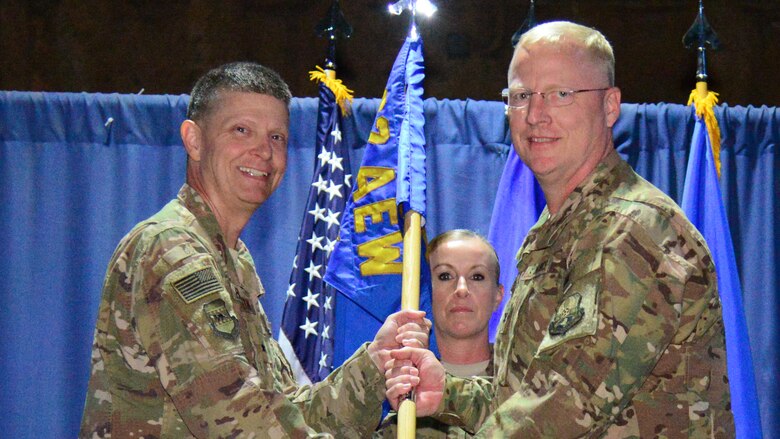 Brig. Gen. Kyle W. Robinson, 332nd Air Expeditionary Wing commander, left, passes the guidon to Col. Bradley D. Nielsen, during the 332nd Expeditionary Medical Group assumption of command ceremony October 16, 2017, in Southwest Asia. The passing of a guidon symbolizes a unit’s transfer of command. (U.S. Air Force photo/Staff Sergeant Samuel O’Brien