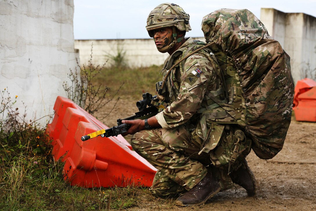 A British soldier scans his sectors while conducting a security patrol.