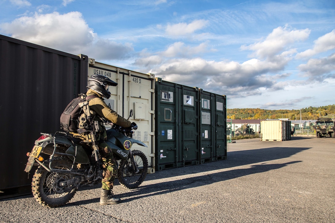 A French soldier on a motorcycle prepares for a convoy to a tactical operation center.