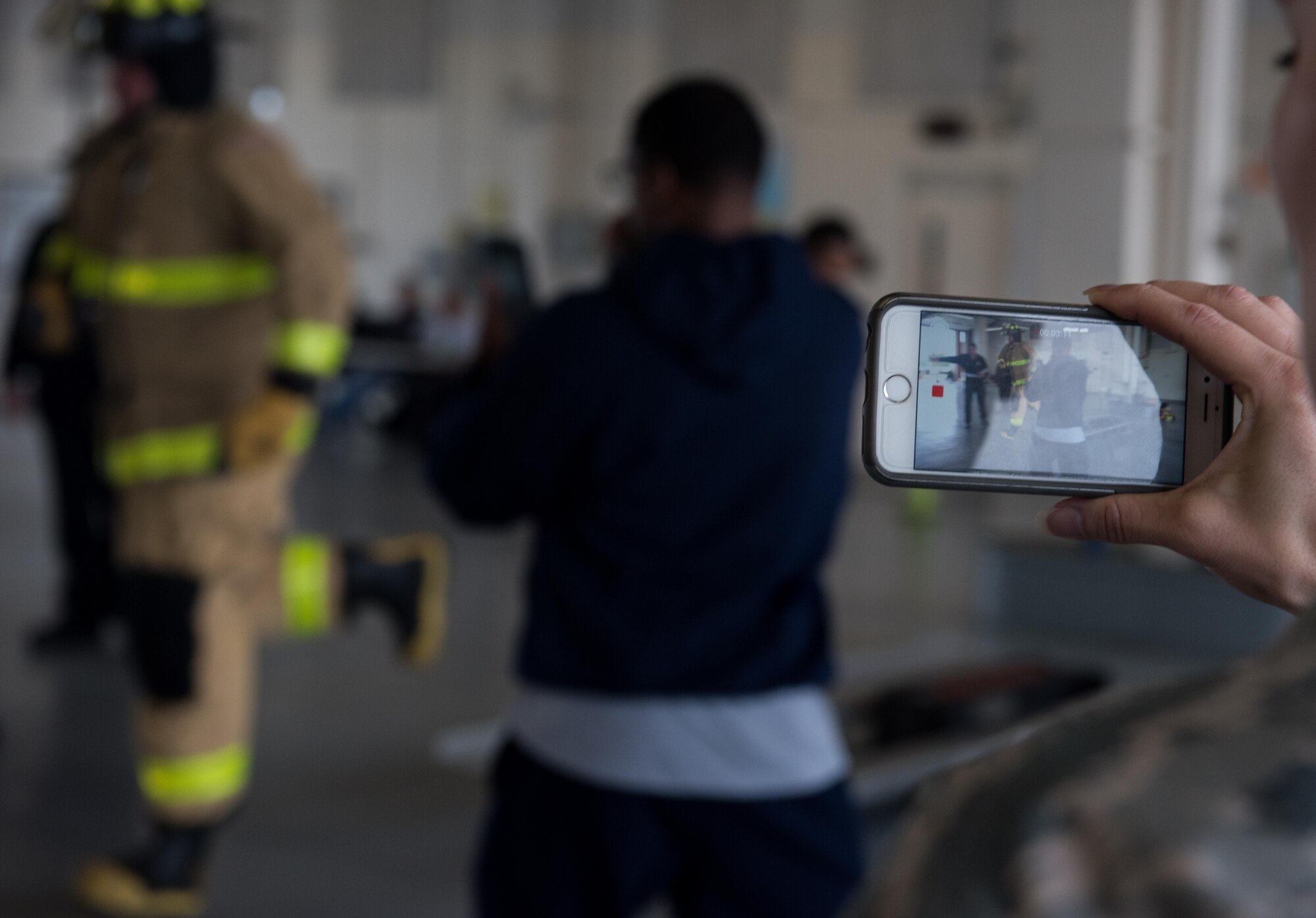 A viewer films participants going through various obstacles at the Firefighter Combat Challenge on Joint Base Langley-Eustis, Va., Oct. 13, 2017.