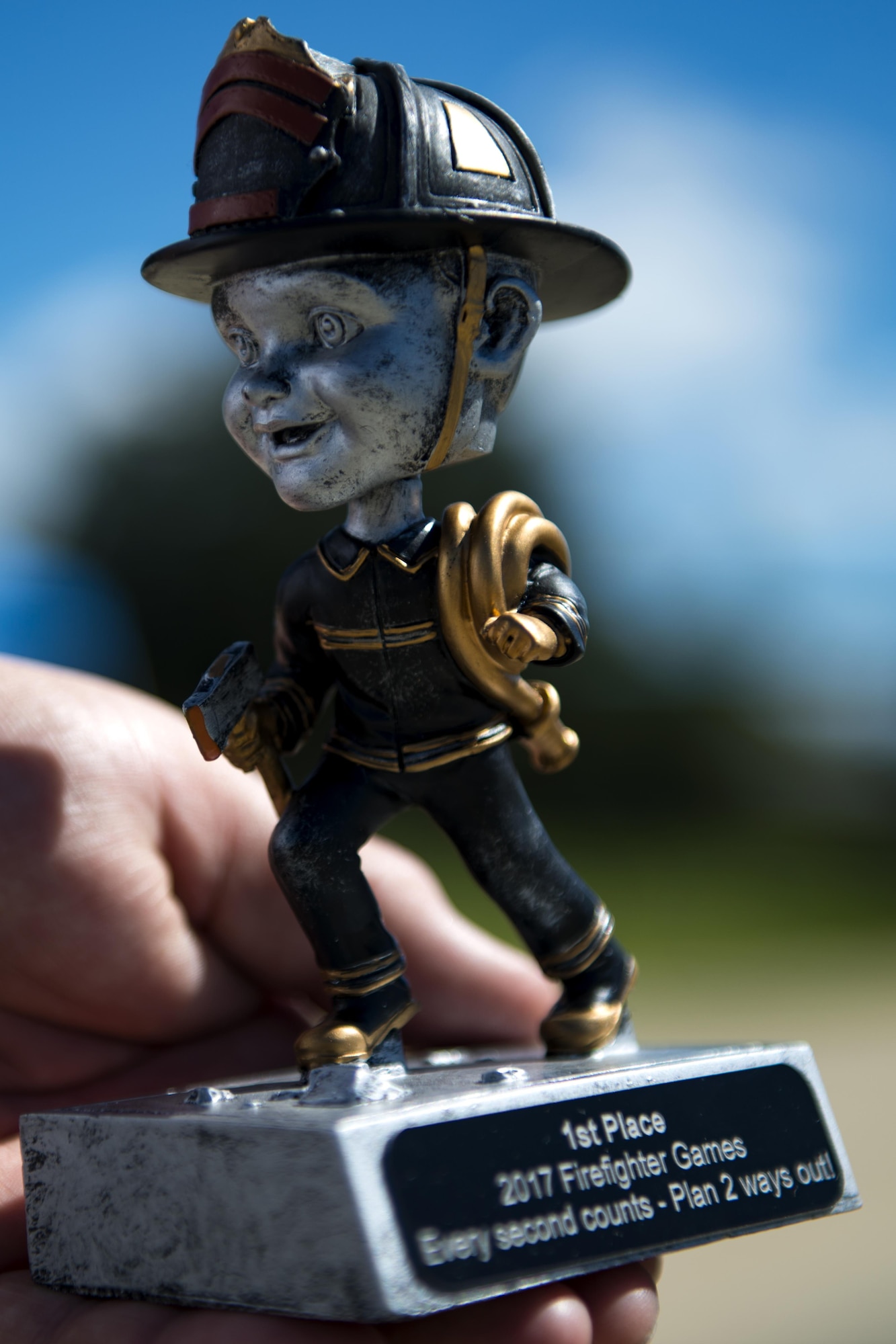 An event organizer assigned to the 23 Civil Engineer Squadron fire department displays a trophy during the 2017 Fire Prevention Week Fire Muster, Oct. 13, 2017, at Moody Air Force Base, Ga. The 23d CES fire department designed the muster to allow teams of Airmen to compete in several events, ranging from a hose roll to a fire truck pull. Event organizers wanted Airmen to experience being a firefighter in a way that got people active. (U.S. Air Force photo by Airman 1st Class Erick Requadt)