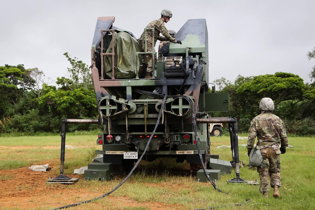 Soldiers prepare to unfold the signal towers for a Patriot missile system.